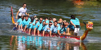 Rowers paddling together in a dragon boat on the water.