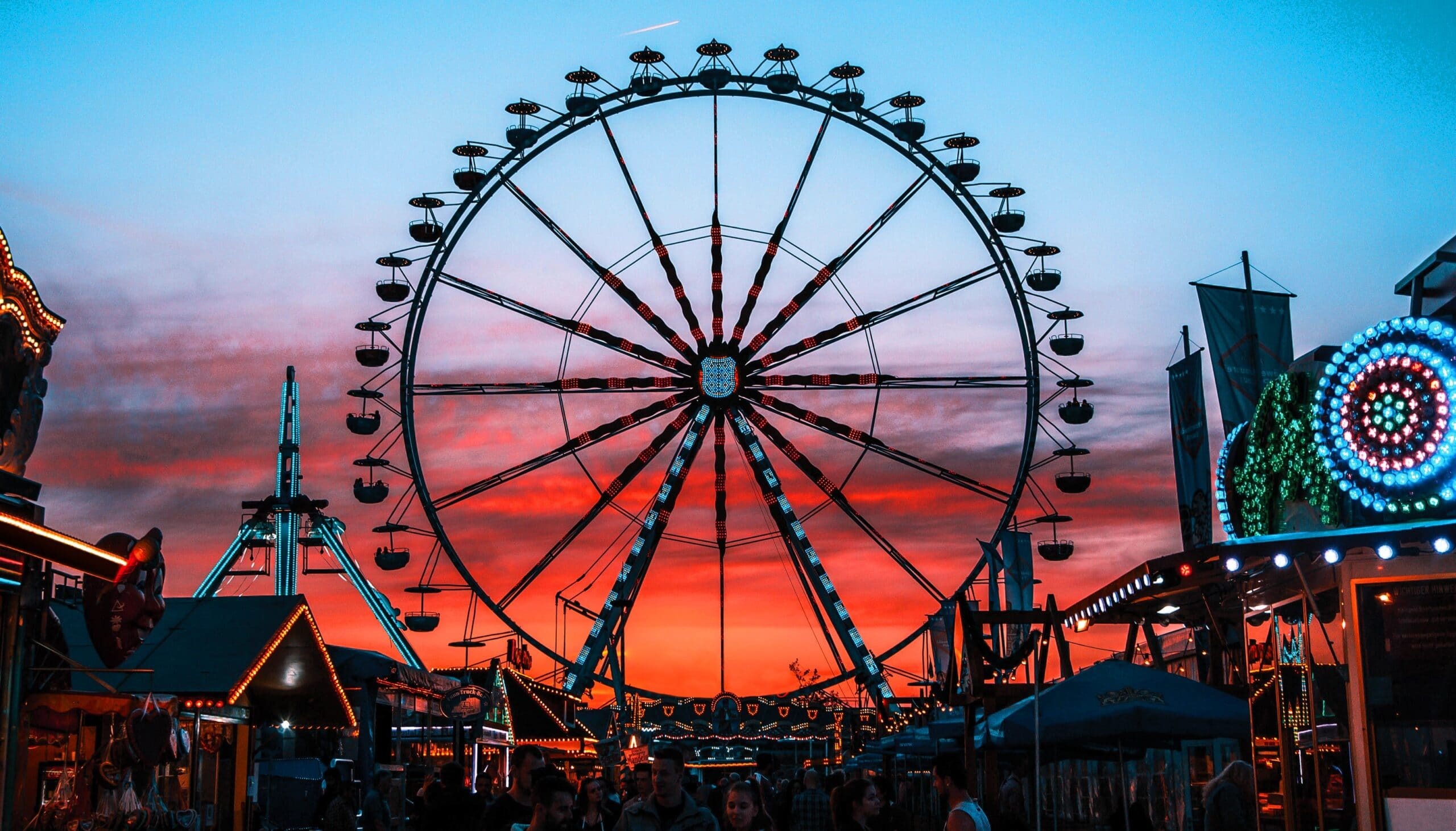 ferris wheel at sunset with fair booths