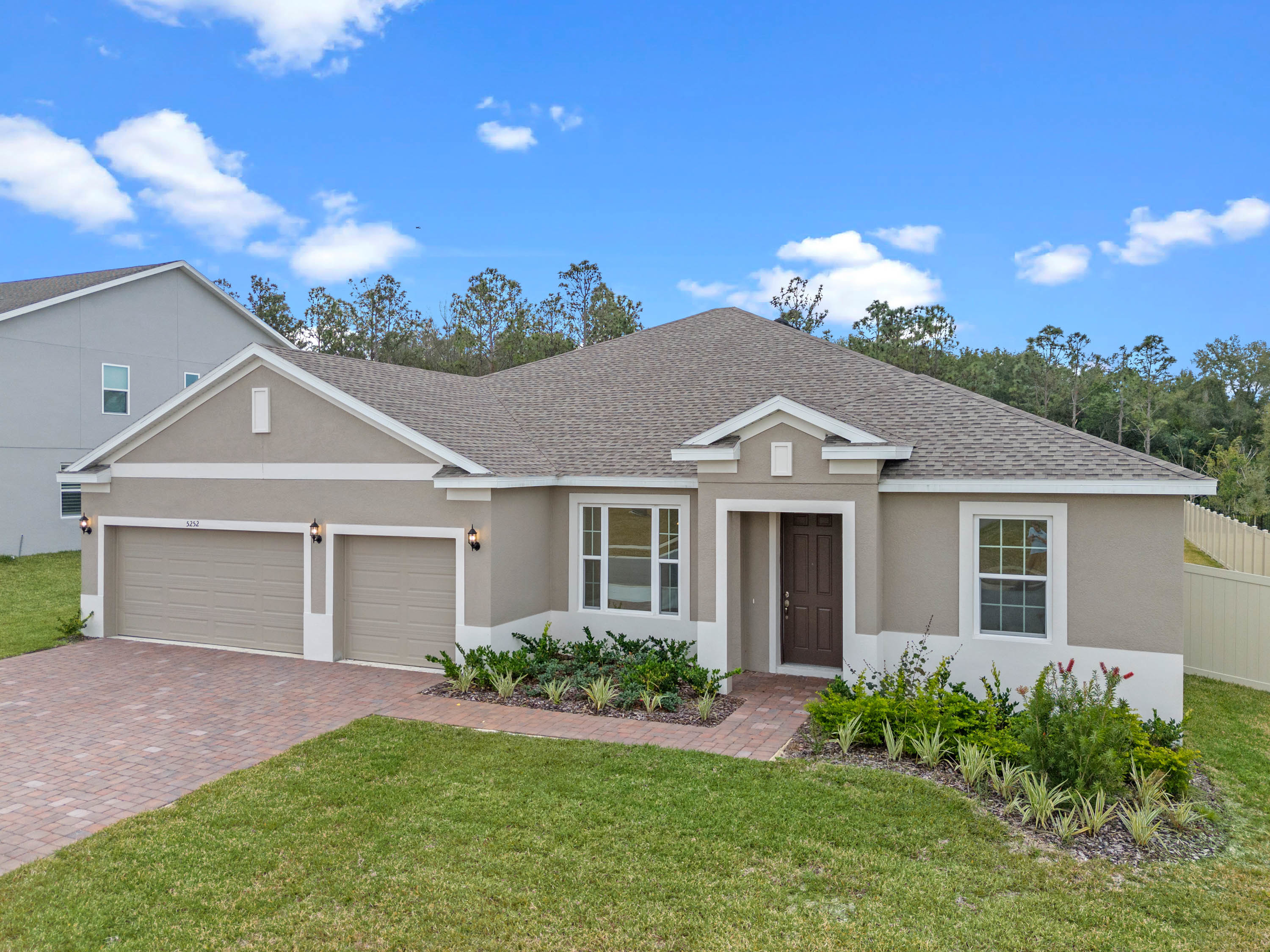 Traditional-style home with three car garage with light brown paint, typical of Mount Dora