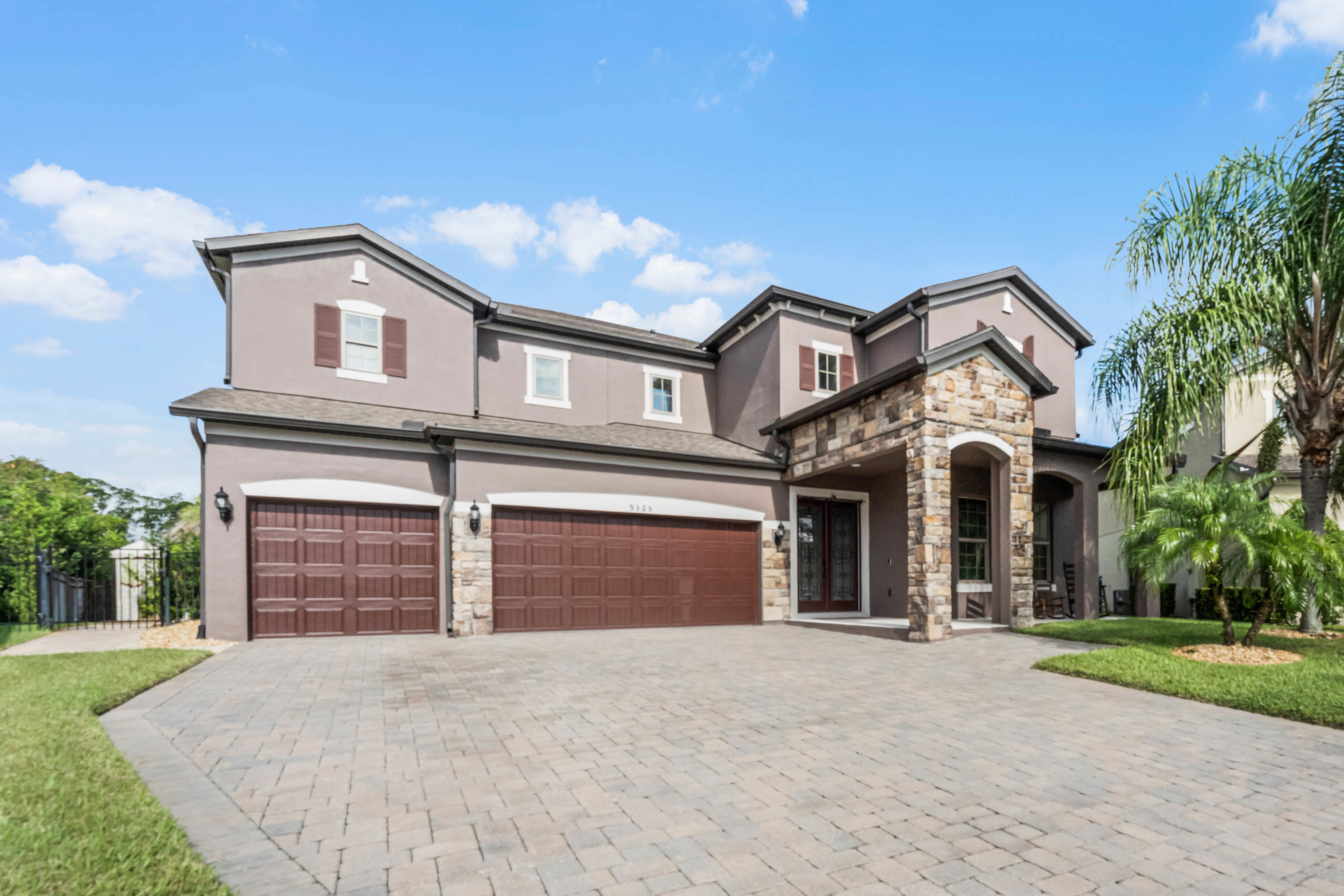 two story home with three car garage and brownish red accent paint