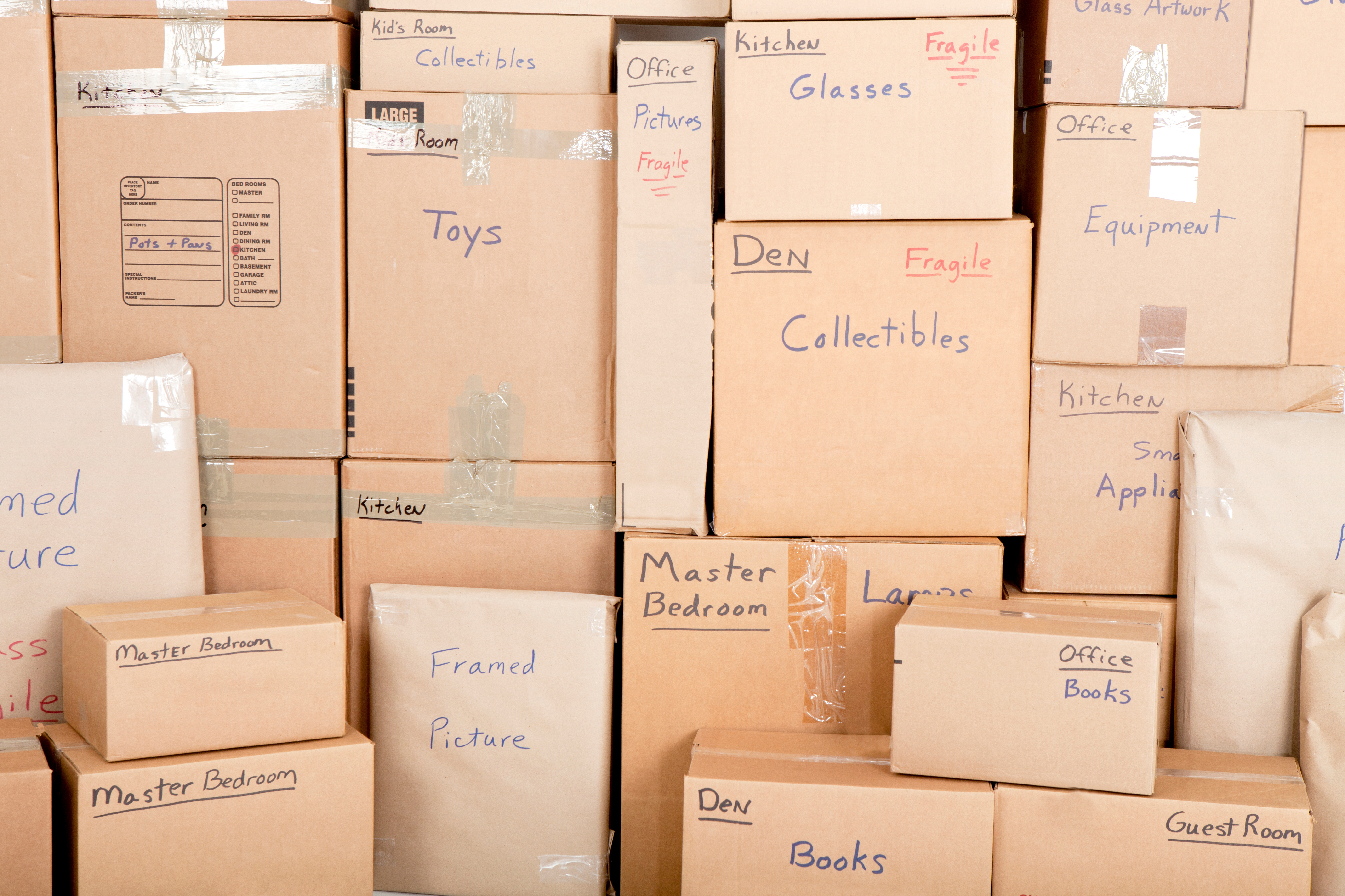 moving boxes stacked and marked with what's inside
