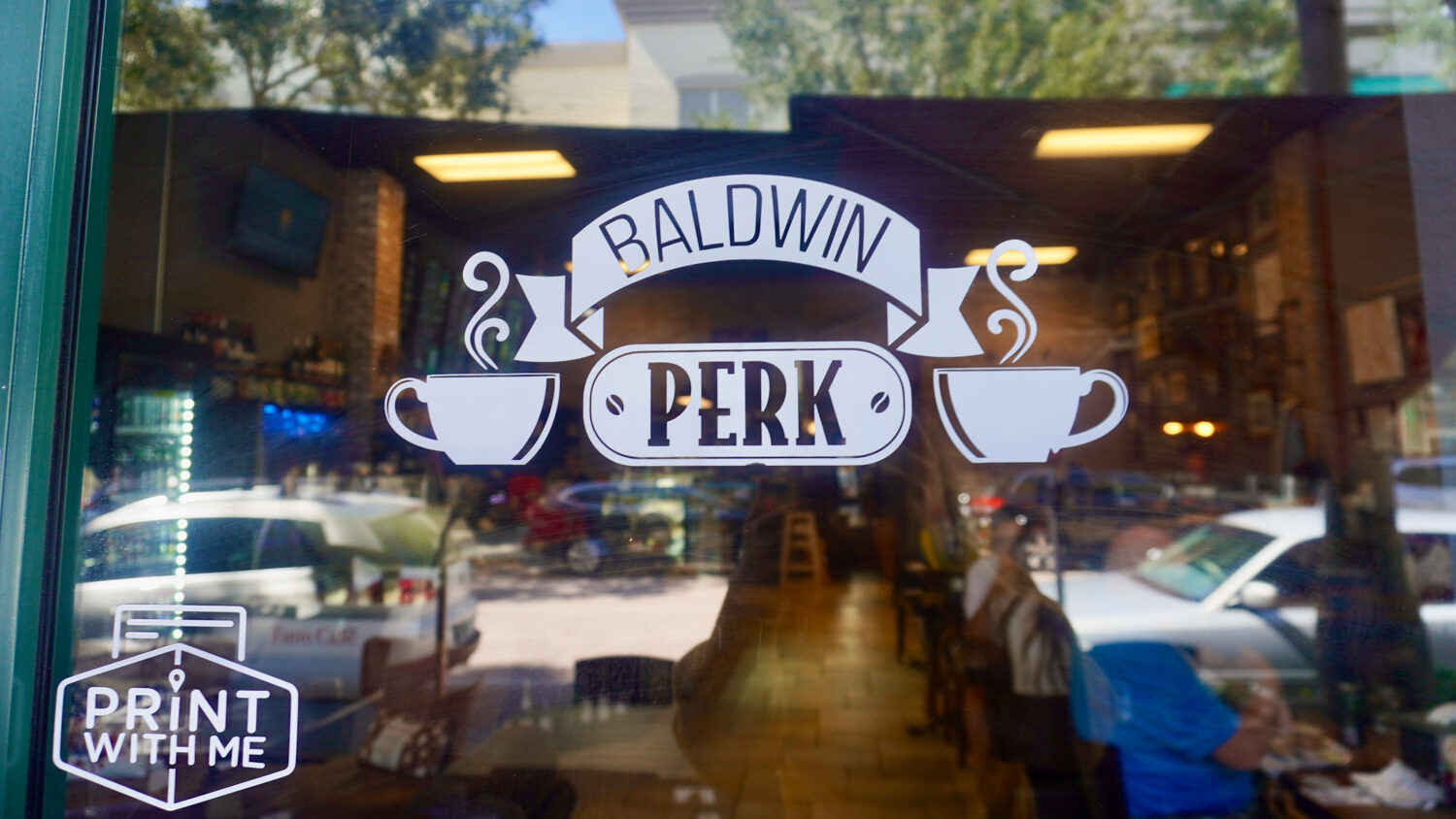 glass window with baldwin perk decal and coffee cups