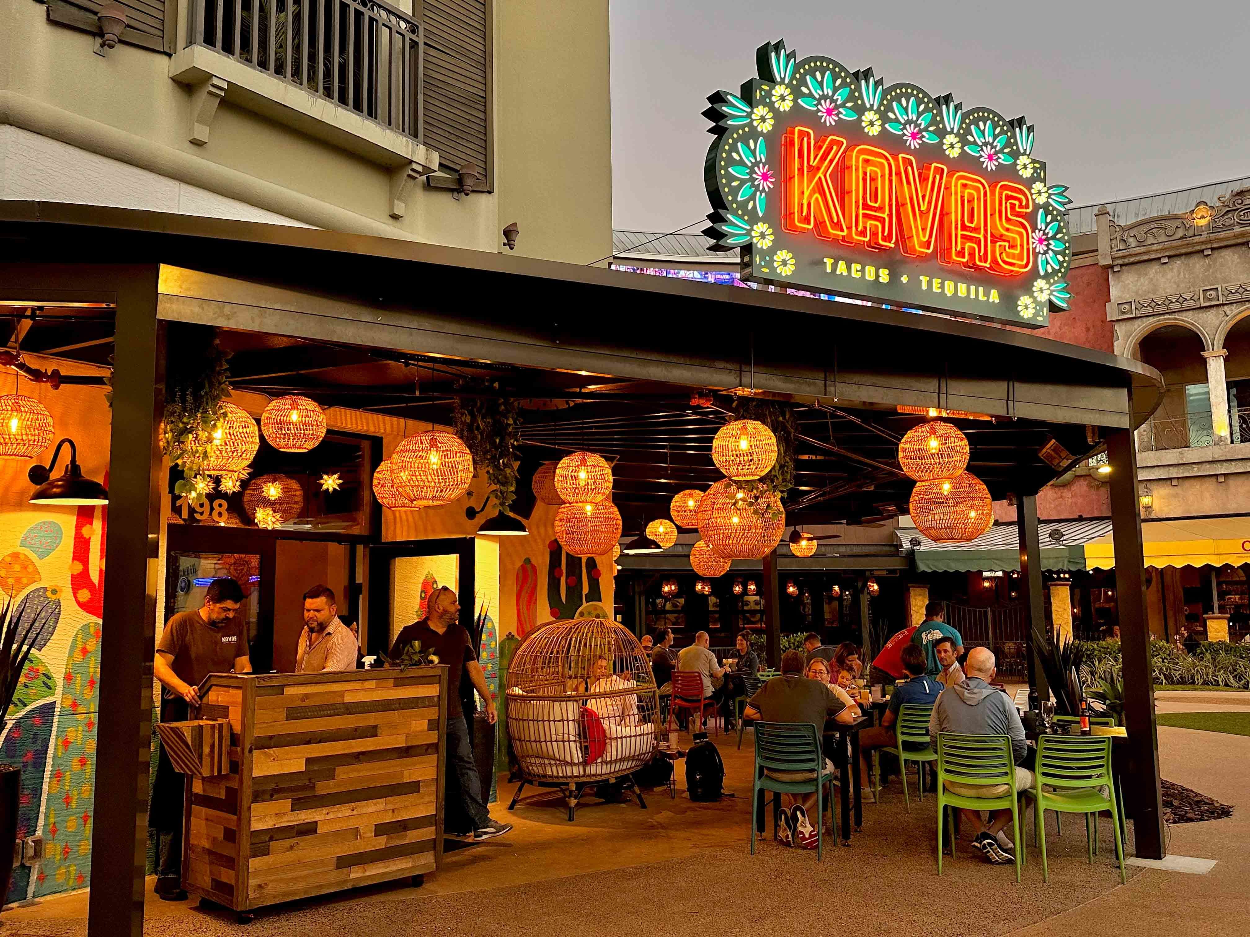 outside seating with kavas sign and hanging lights over tables and chairs