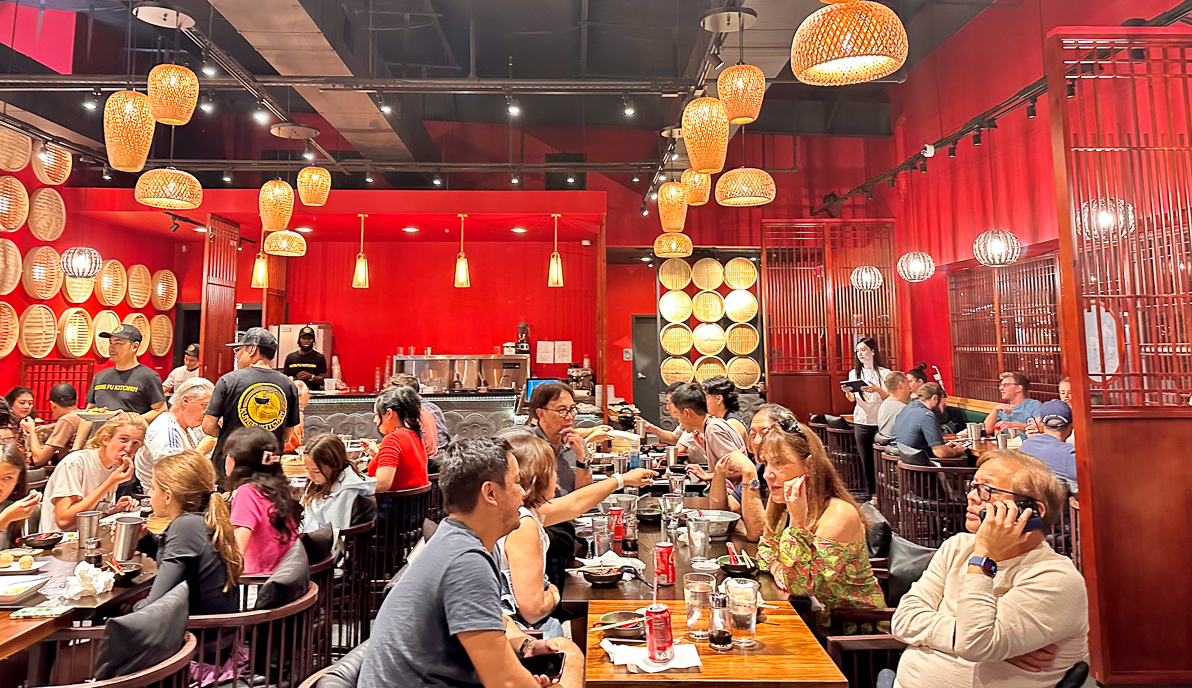 wide shot of inside restaurant with red walls and paper lantern lights