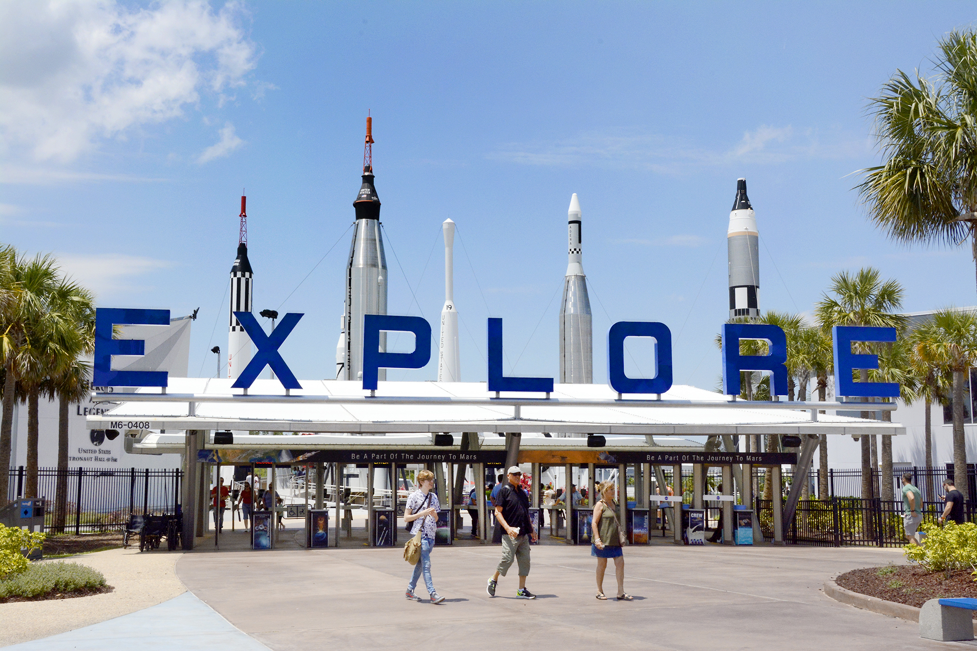 Guests walk by the entrance to Kennedy Space Center Visitor Complex.