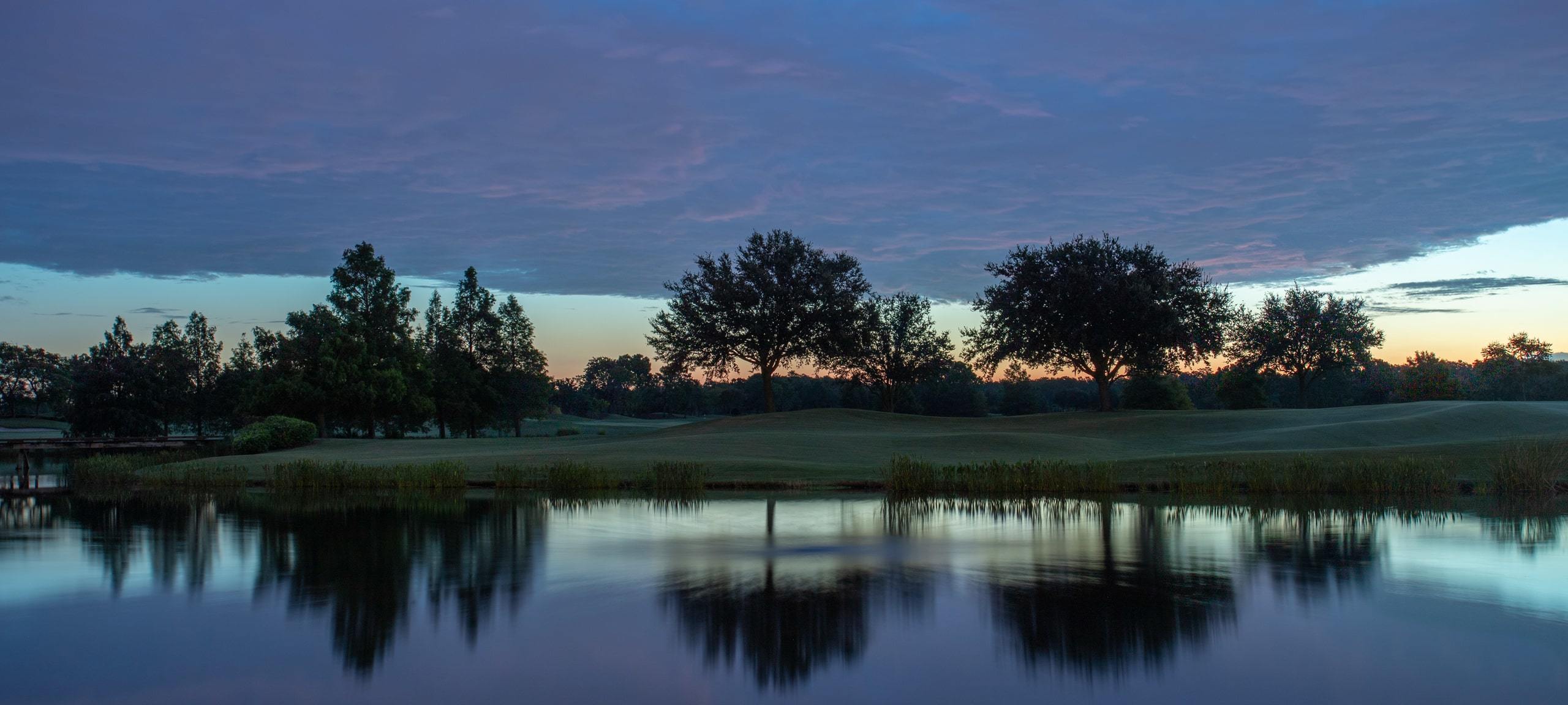 Blue sunset over golf course with lake reflections, typical of Bay Hill