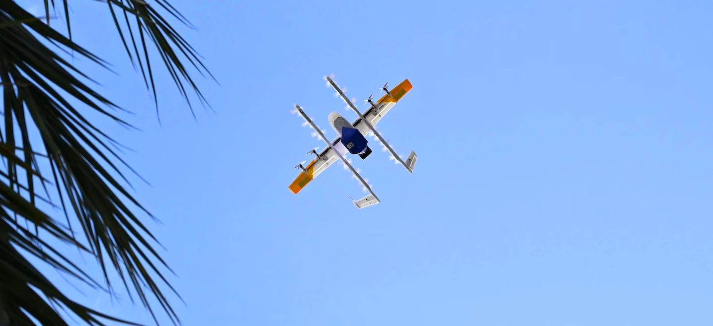 Looking up at a delivery drone carrying a package.