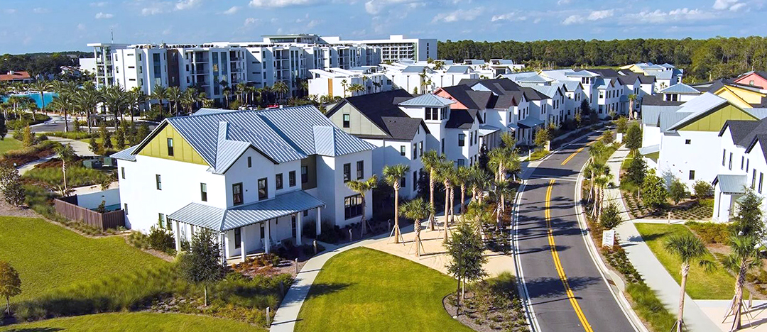 A row of vacation homes with a hotel in the background.