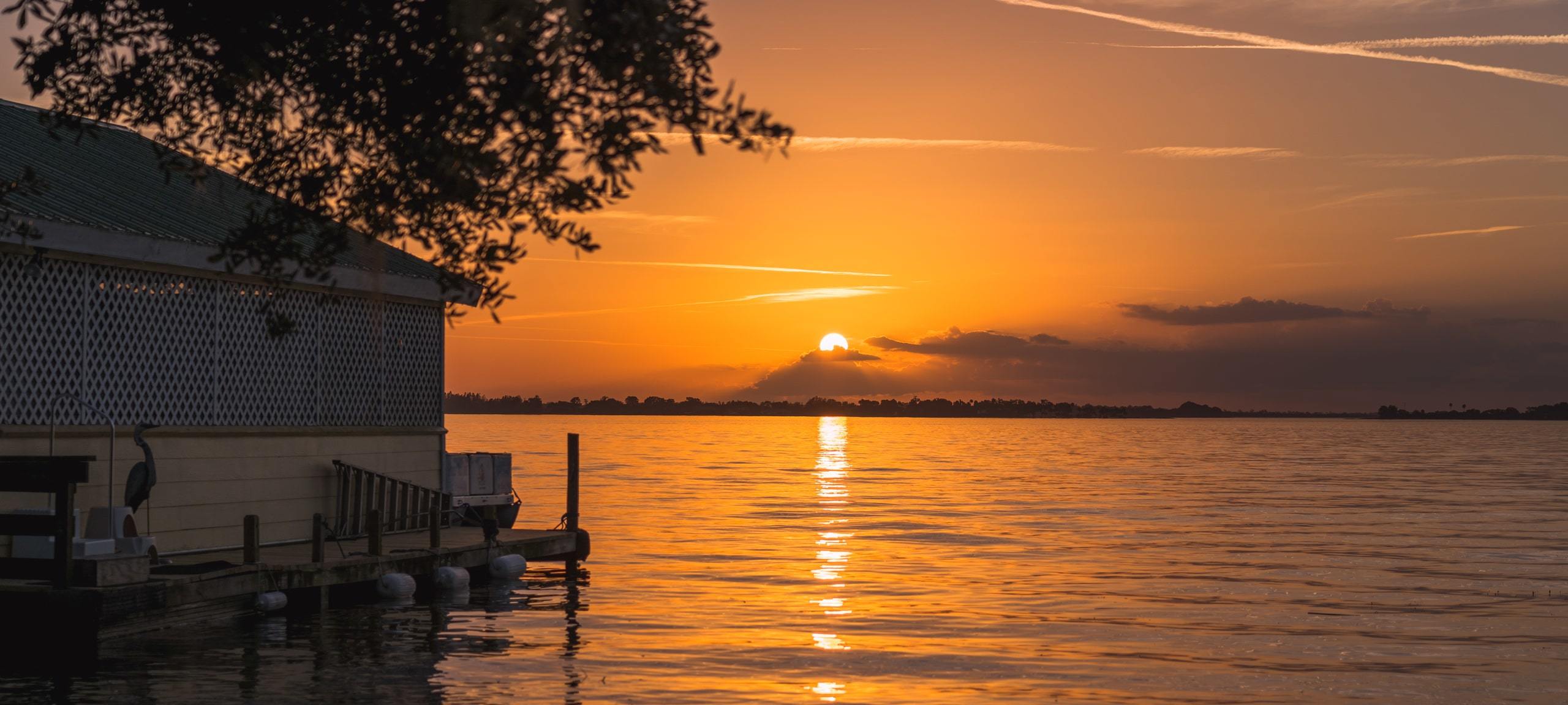 Sunset over Lake Dora with a Mount Dora private dock and boat house on far left
